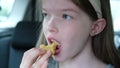 little girl eating chicken nuggets in the car, fast food