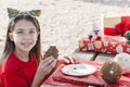 Little girl eating chocolate cake at Christmas picnic