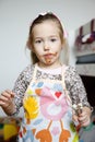 Little girl eating chocolate off the mixer beater