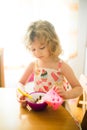 Little girl eating corn balls in the kitchen