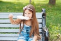 Little girl eating cotton candy sitting on a bench in the park summer Royalty Free Stock Photo