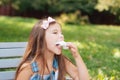 Little girl eating cotton candy sitting on a bench in the park summer Royalty Free Stock Photo