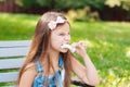 Little girl eating cotton candy sitting on a bench in the park summer Royalty Free Stock Photo