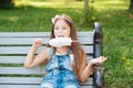 Little girl eating cotton candy sitting on a bench in the park summer Royalty Free Stock Photo