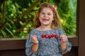 Little girl eating delicious strawberries on skewers, savoring the simple pleasures of family and healthy food. Happy Royalty Free Stock Photo