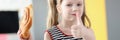 Little girl eating delicious sweet bun and showing thumb up Royalty Free Stock Photo