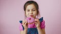 Little girl eating donut with sprinkles, smiles