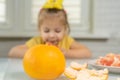 Little girl eating grapefruit