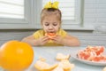 Little girl eating grapefruit