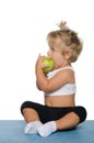 Little girl eating green apple