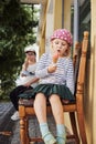 Little girl eating italian gelato with her sister on summer day at street Italian cafe, candid kid