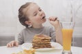 little girl eating pancakes and eyes close Royalty Free Stock Photo