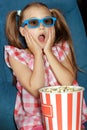 Little girl eating popcorn during a movie Royalty Free Stock Photo