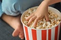 Little girl eating popcorn while watching TV at home, closeup Royalty Free Stock Photo