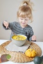 Little Girl Eating Pumpkin Cream-Soup at Home