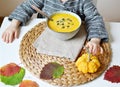 Little Girl Eating Pumpkin Cream-Soup at Home