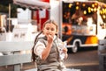Little girl eating rench fries with sauce at street cafe outside. Concept of fast food and children Royalty Free Stock Photo