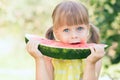 Little girl eating ripe watermelon in sunny summer garden Royalty Free Stock Photo