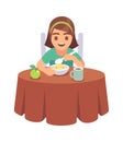 Little girl eating. Smiling hungry toddler sits at table and eats delicious cereal or muesli with spoon on breakfast