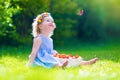 Little girl eating strawberry watching a butterfly Royalty Free Stock Photo