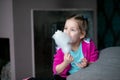 Little girl eat sweet cotton candy at home. Happy kindergartener bite candy floss. Favourite sweets, sugary food.