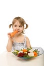 Little girl eating vegetables - chomping a carrot Royalty Free Stock Photo