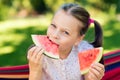 Little girl eating watermelon slices in the garden Royalty Free Stock Photo