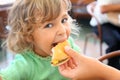 Little girl eats hamburger from mothers's hand Royalty Free Stock Photo