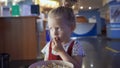 Little girl eats popcorn in movie theater. Media. Cute girl eating popcorn in waiting room at cinema. Pretty girl cute