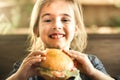 A little girl eats a sandwich in a cafe Royalty Free Stock Photo