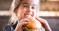 A little girl eats a sandwich in a cafe Royalty Free Stock Photo