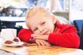 Little Girl Eats Sweets and Drinks Tea in Cafe. Royalty Free Stock Photo