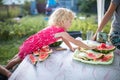 Little girl eats watermelon in summer. The child grimaced as he tasted the sour berry, the summer food to tast