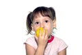 Little girl eats yellow fruit