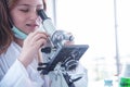 Little girl at an elementary school, using microscope research, testing in science class. Toddler girl doing biochemistry research Royalty Free Stock Photo