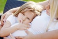 Little girl embraces a stomach of pregnant mother. Serious and thoughtful look Royalty Free Stock Photo