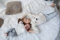 Cute girl with a newborn baby brother relaxing together on a white bed Royalty Free Stock Photo