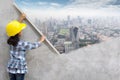 Little girl engineering holding plastering tools painting skyscraper on wall