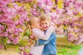 Little girl enjoy spring flowers. Giving all flowers to her. Surprising her. Kids enjoying pink cherry blossom. Romantic Royalty Free Stock Photo