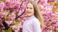 Little girl enjoy spring. Kid on pink flowers of sakura tree background. Kid enjoying cherry blossom sakura. Happy Royalty Free Stock Photo