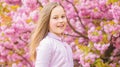 Little girl enjoy spring. Kid on pink flowers of sakura tree background. Kid enjoying cherry blossom sakura. Happy Royalty Free Stock Photo