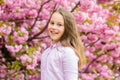 Little girl enjoy spring. Kid on pink flowers of sakura tree background. Kid enjoying cherry blossom sakura. Happy Royalty Free Stock Photo