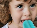 Little girl enjoying her blue Popsicle