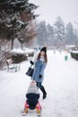 Little girl enjoying sledding. Mom sledding her little daughter. Family vacation on Christmas eve outdoors Royalty Free Stock Photo