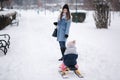 Little girl enjoying sledding. Mom sledding her little daughter. Family vacation on Christmas eve outdoors Royalty Free Stock Photo