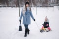 Little girl enjoying sledding. Mom sledding her little daughter. Family vacation on Christmas eve outdoors Royalty Free Stock Photo