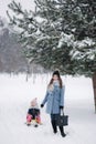 Little girl enjoying sledding. Mom sledding her little daughter. Family vacation on Christmas eve outdoors Royalty Free Stock Photo