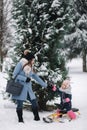 Little girl enjoying sledding. Mom sledding her little daughter. Family vacation on Christmas eve outdoors Royalty Free Stock Photo