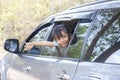 Little girl enjoying the trip smile and show hand out of car window. Royalty Free Stock Photo