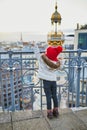 Little girl enjoying view to Parisian skyline with roofs and dramatic colorful sunset